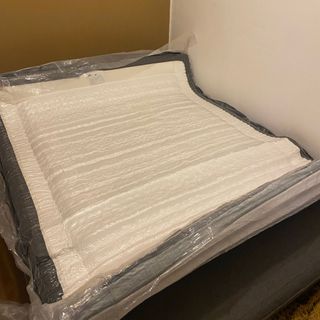 Otty Pure Plus mattress in plastic packaging on bed