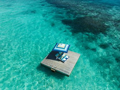 Blue missoni patterned parasol and lounger on blue sea at One & Only Reethi Rah Maldives resort