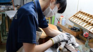 Care is taken at every stage in the process - here, a craftsman taps in frets