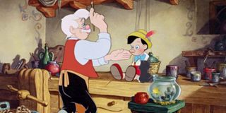Pinocchio Gepetto painting Pinocchio's face at his work bench