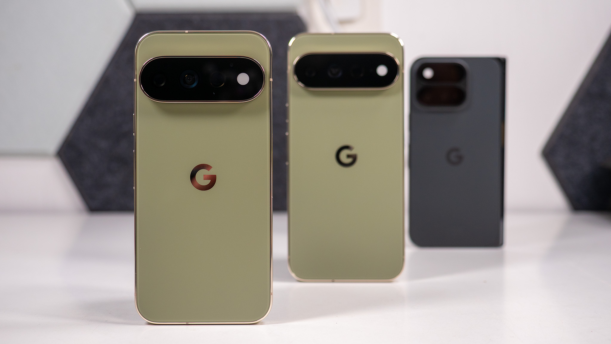 A Google Pixel 11 Pro in focus, with a Google Pixel 11 XL and Pixel 11 Pro Fold behind