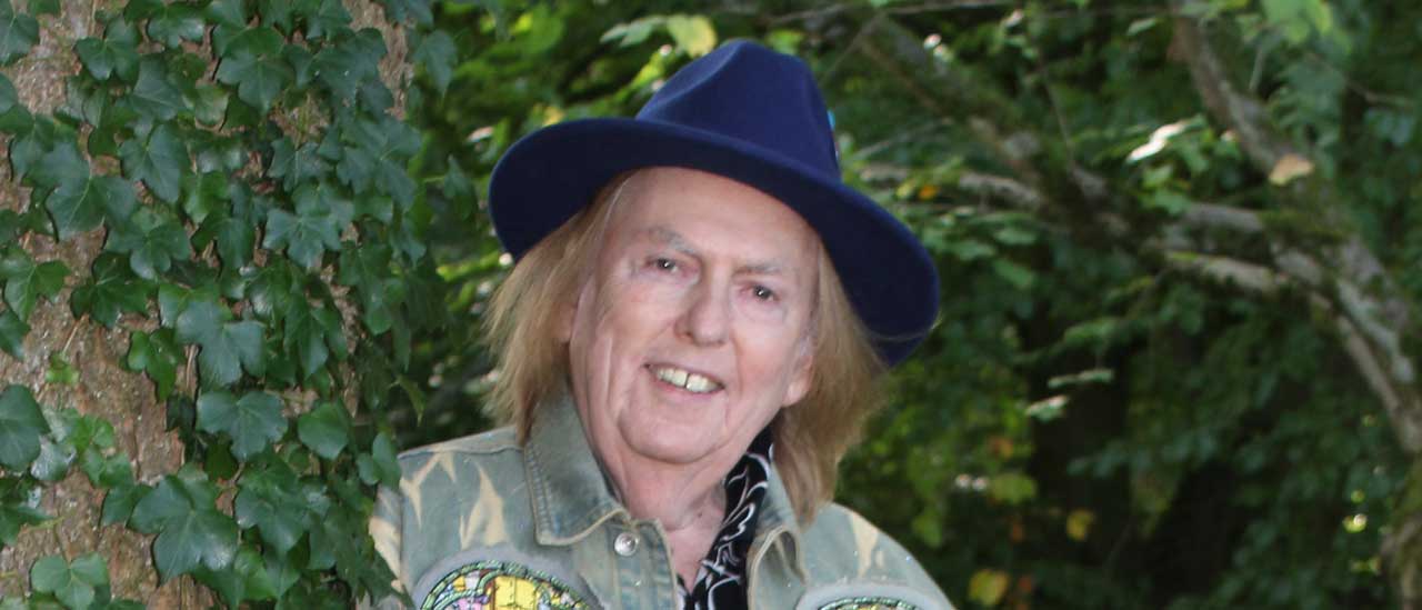 Dave Hill standing in front of a hedge