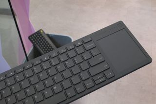 Framework's Wireless Touchpad Keyboard with a keyboard in the bin behind it.