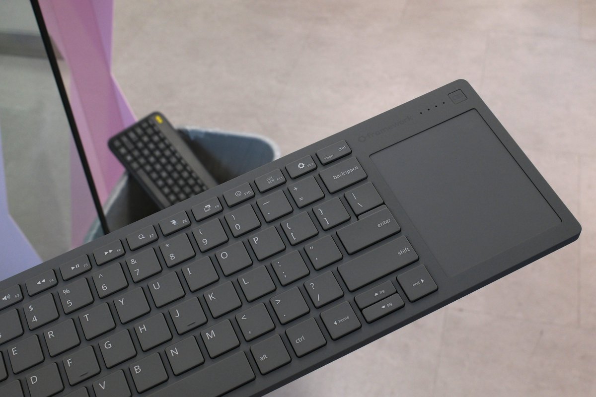Framework's Wireless Touchpad Keyboard with a keyboard in the bin behind it.