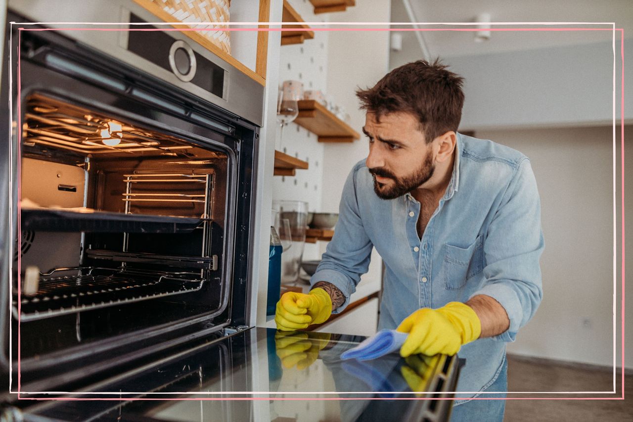 A man wearing rubber gloves peering into the open door of an oven