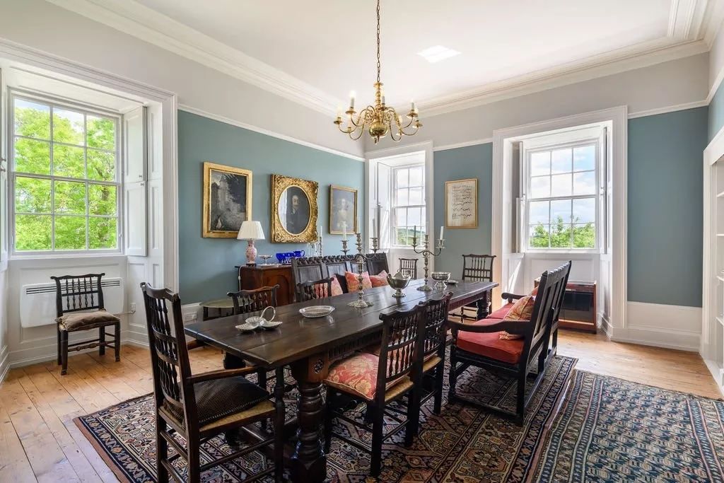 The dining room, with a wooden table and chairs and nice blue wallpaper
