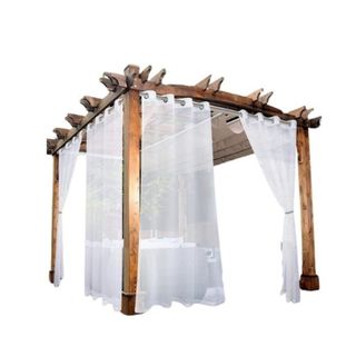 A set of four white curtains hanging from an angled wooden pergola