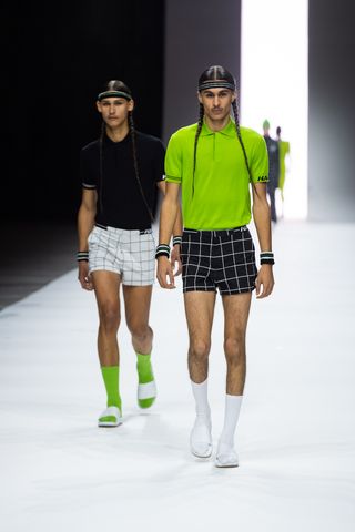Two models on runway in shorts, polo shirts and headbands