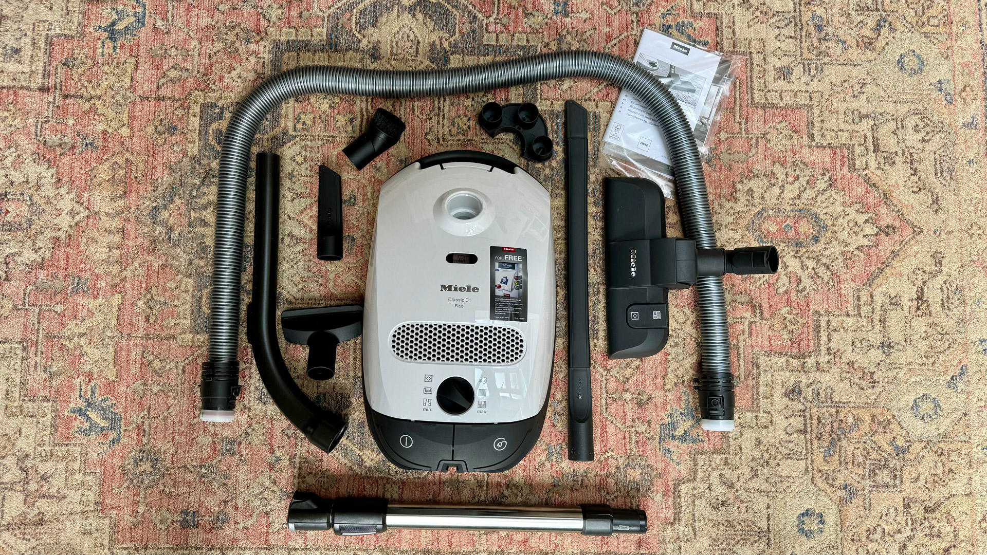 Miele Classic C1 Flex and accessories on a rug