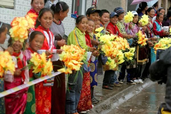 Tibetan children cheers on the riders.