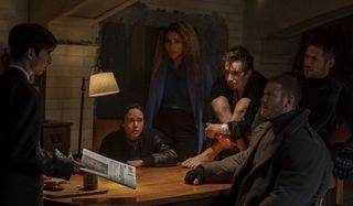 The Umbrella Academy cast circled around a table, listening to a young boy