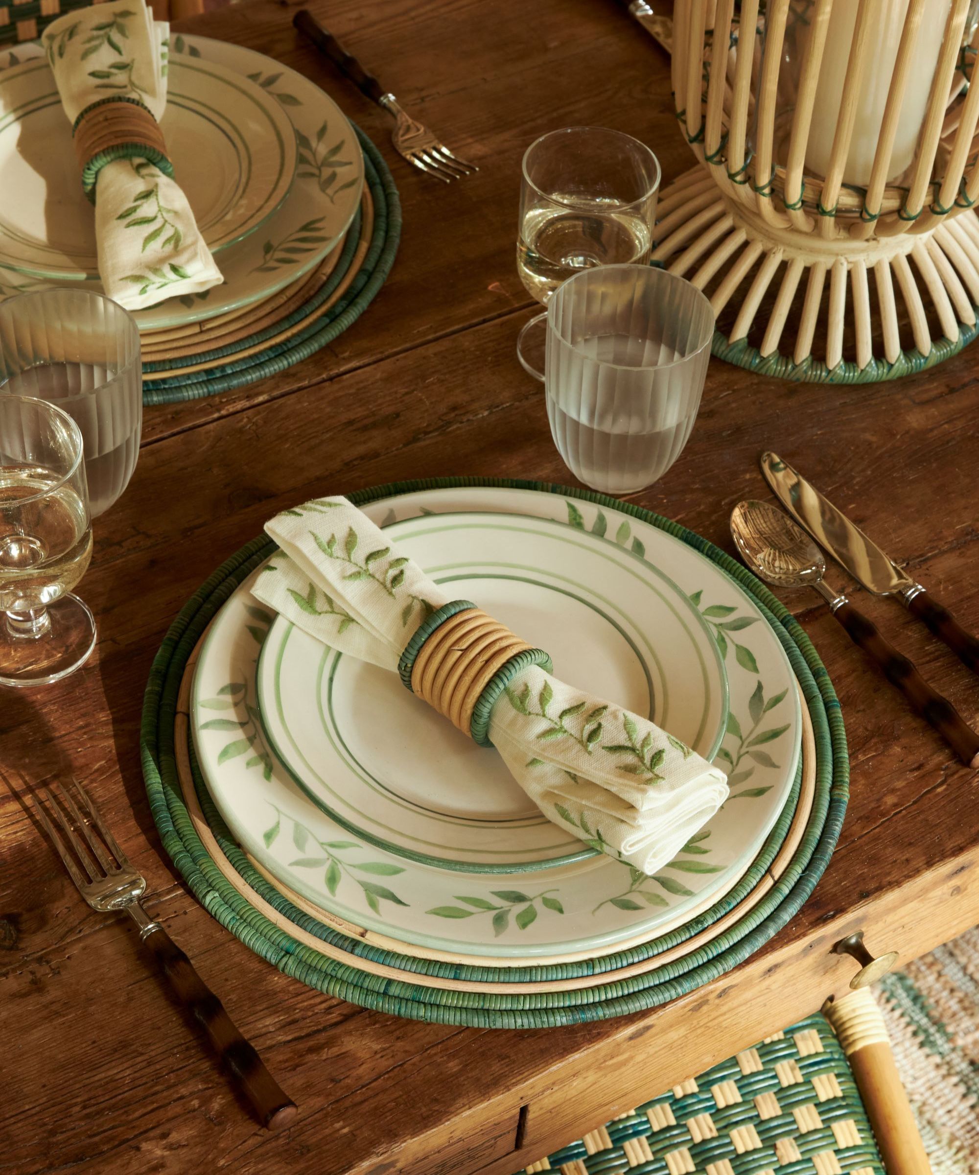 white dinner plates with green leaf design and matching serviette