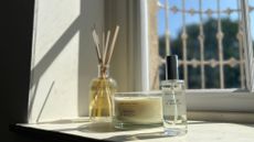 Aldi Lemon and Neroli Hotel Collection diffuser, room spray, and triple wick candle on a windowsill
