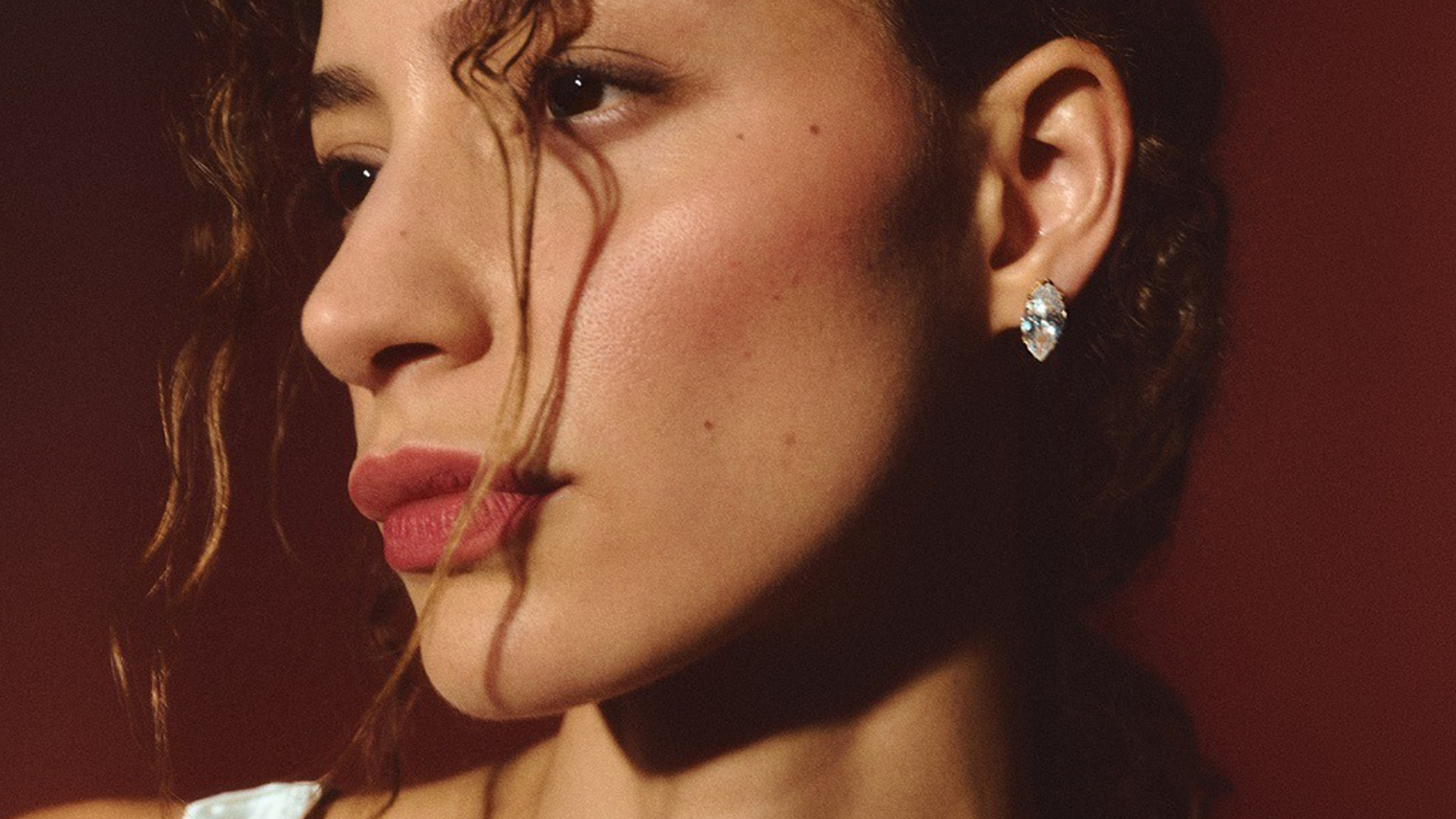 Photo of model wearing diamond stud earrings.