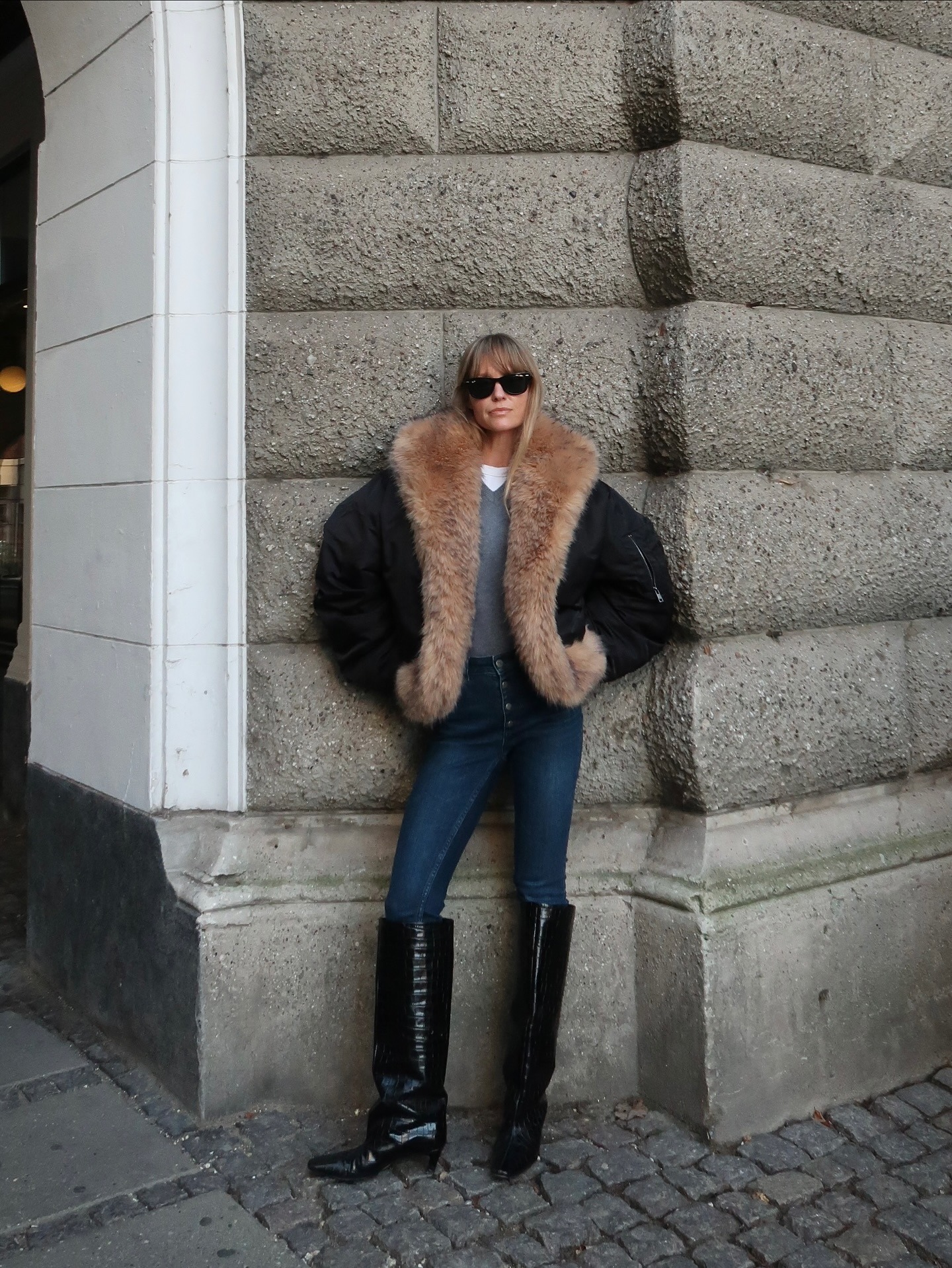 Fashion person Jeanette Madsen shows what to wears to the pub. She wears skinny jeans, a fur coat and knee high boots.