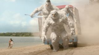 A trio of jacked snowmen emerge from a freezer truck onto a beach in Red One.