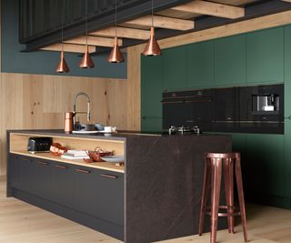 modern kitchen with large island housing sink, tap and kitchen burner with open shelving to front, pendant lighting above and green floor to ceiling cabinets with inbuilt appliances behind it