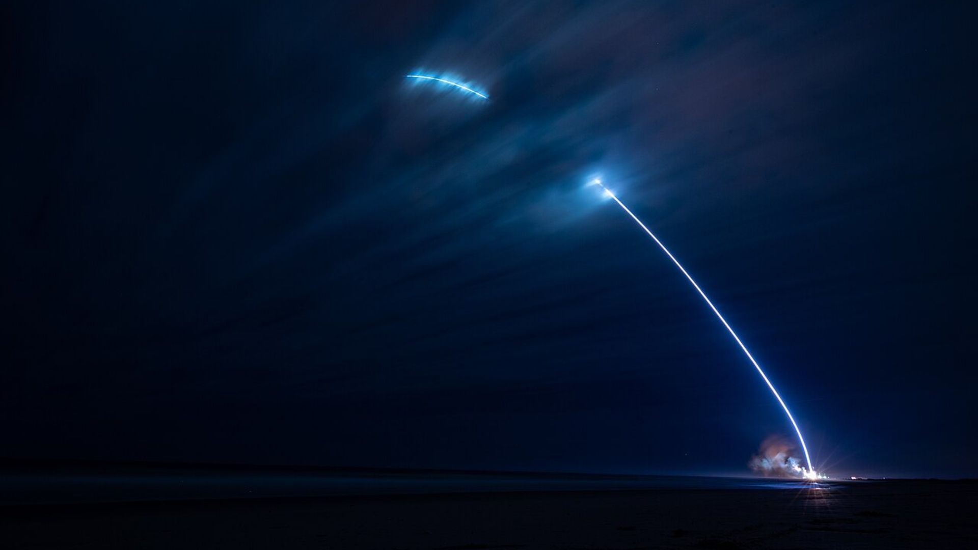 A timelapse photo of the first New Glenn launch showing a streak of light shooting into the night sky