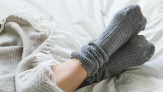 woman wearing grey socks in bed