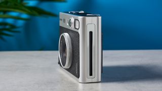 A black and gray Fujifilm Instax mini Evo hybrid instant camera