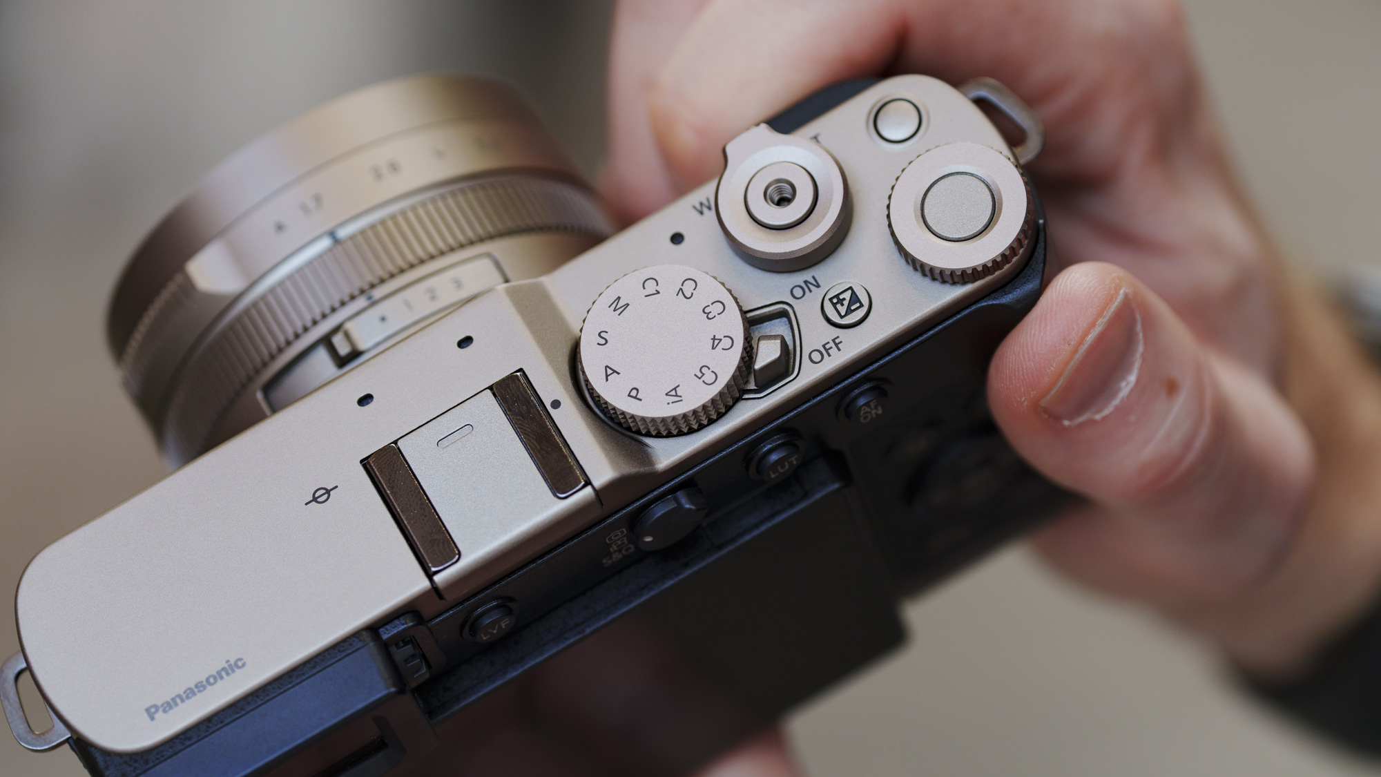 Man holding the Panasonic Lumix L10 compact camera in an urban setting of Japan