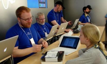 Apple employees help a young customer in Portland, Ore.: To become a "Genius," employees must go through a mandatory 14-day course.