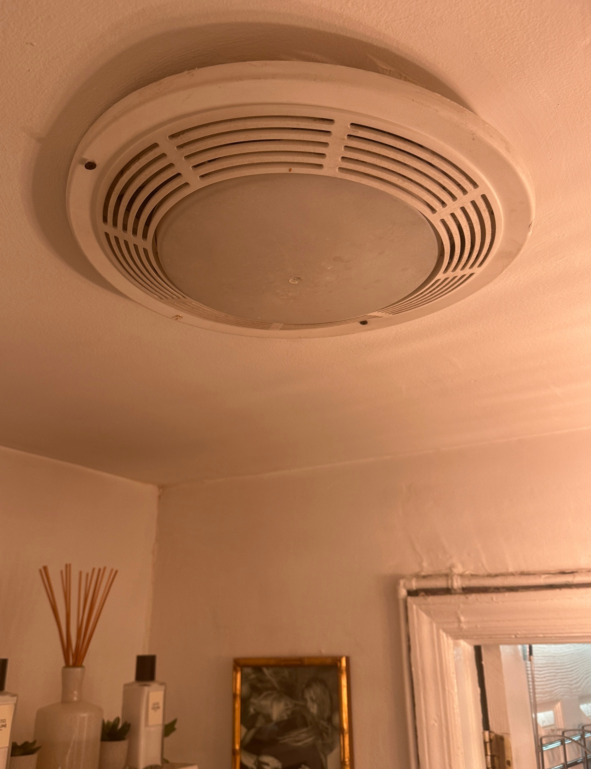 Detail shot of a ceiling light inside of a small NYC bathroom