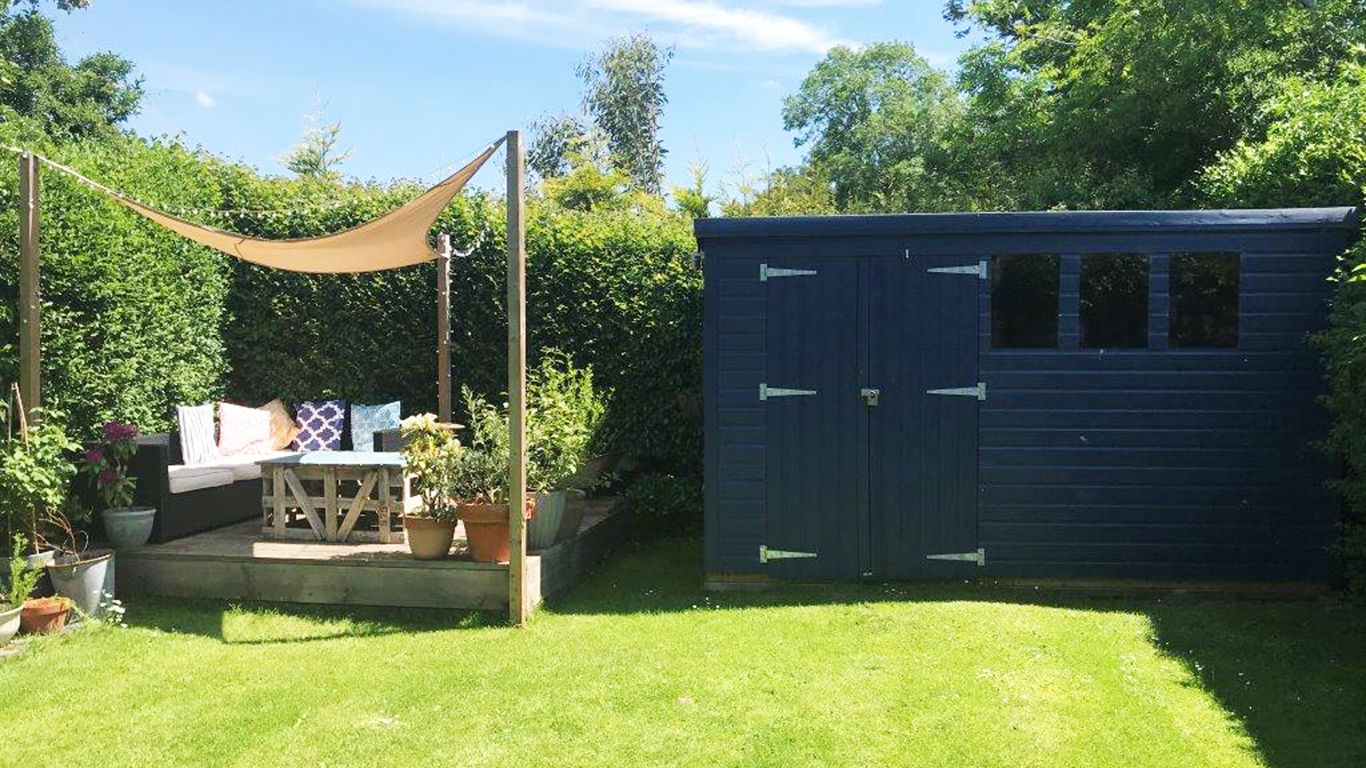 raised garden deck and blue shed in garden