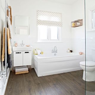 bathroom with white wall and white bathtub and wooden floor