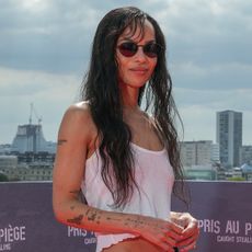 Zoe wears a white cropped tank top, black silk maxi skirt, and open toe heeled mules.