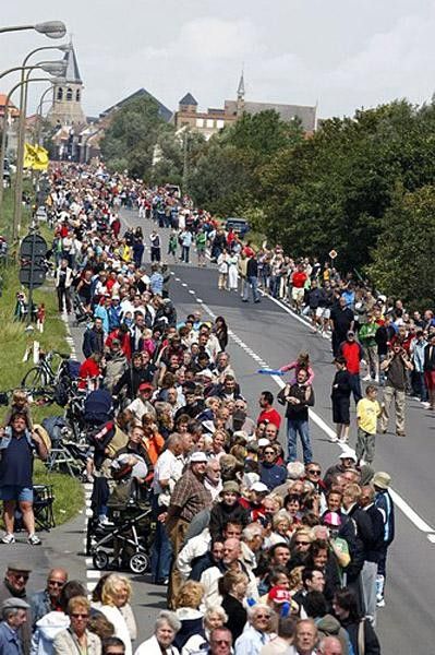 Fans mill around waiting for the peloton to come