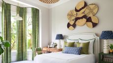 Bedroom accent wall ideas featuring round wicker decor in a neutral scheme with bright green and blue accents and drapes.