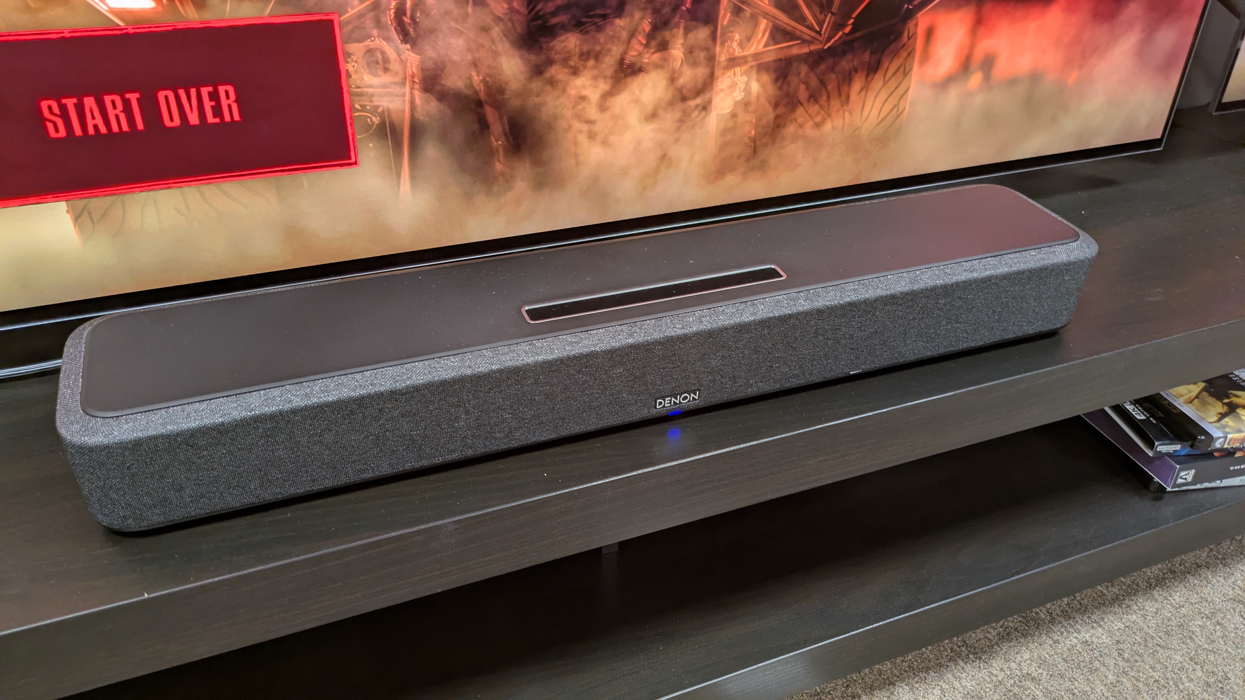 Denon Home 550 soundbar on dark wood stand
