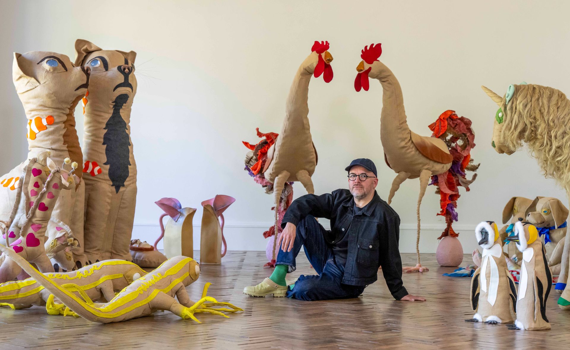 designer sitting amid animal sculptures