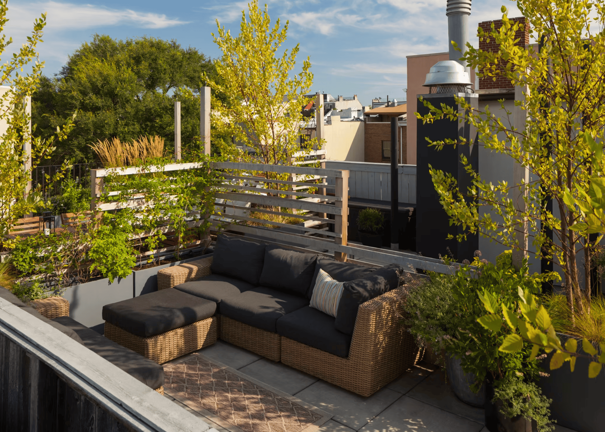 balcony with sofa and footstool and a trellis behind with climbing vines