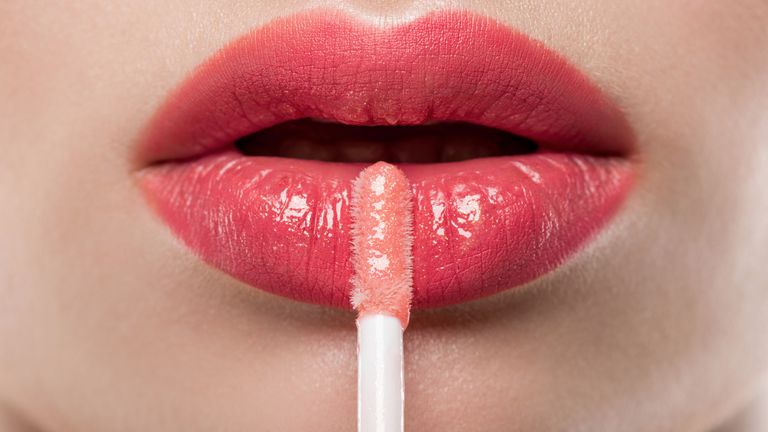 Woman applying lipgloss 