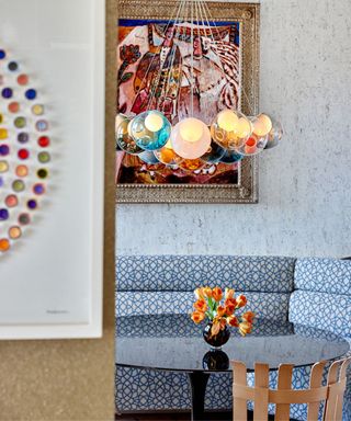 dining area with blue patterned bench, round table and colorful artwork