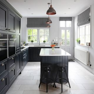 kitchen with white wall and black coloured storage