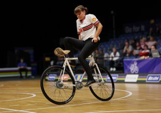 Katarina Howe sitting backwards on the handlebars of a moving bike