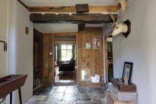 hallway with wooden doors and beams and stone tile flooring