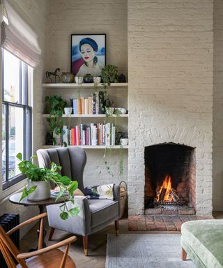 Living room fall decor with fireplace, brick wall and shelving