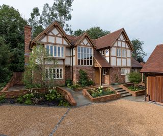 oak frame self build by Border Oak with sloping gravel driveway