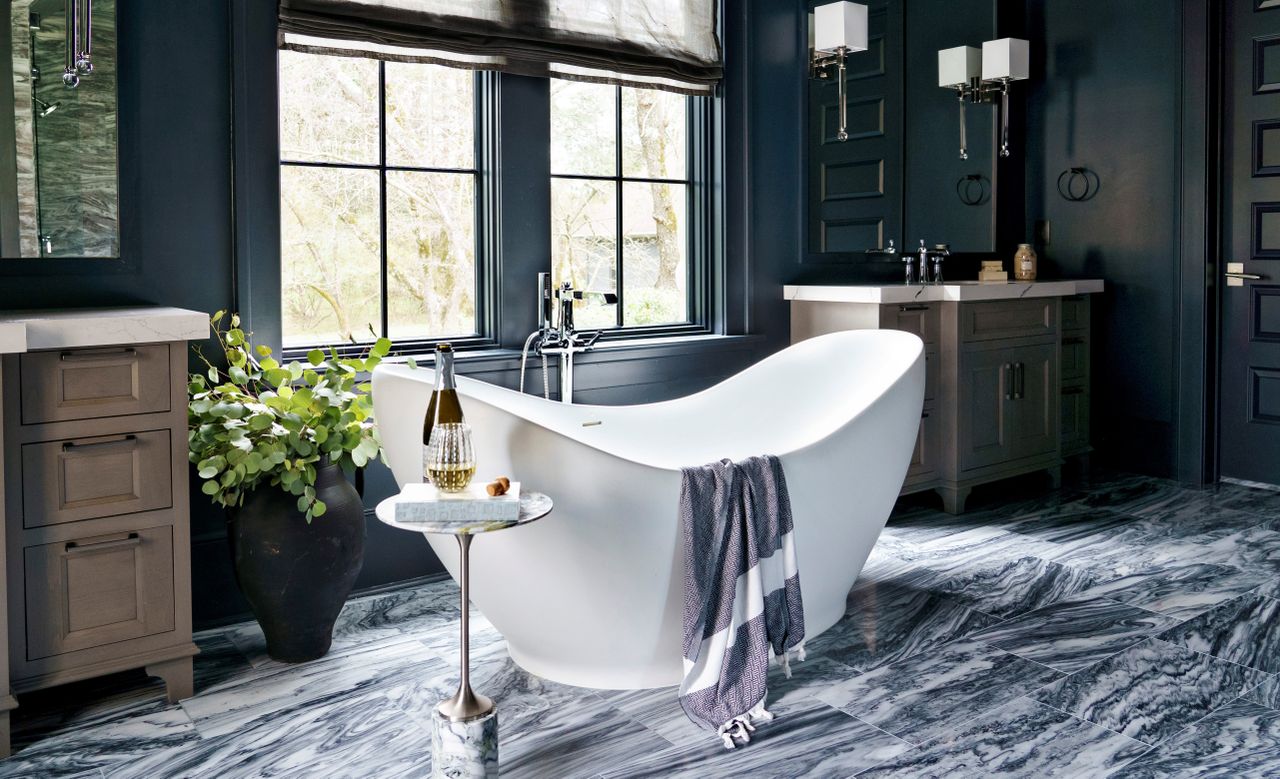 Marble on the floor of a modern bathroom with dark blue walls