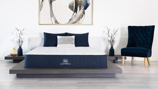 The Brooklyn Bedding Signature Mattress shown in a stylish bedroom and placed next to a blue velvet chair