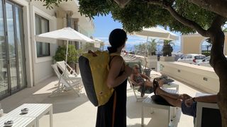 Julia Clarke wearing the Fjallraven High Coast Duffel 36 in yellow as a backpack standing next to pool