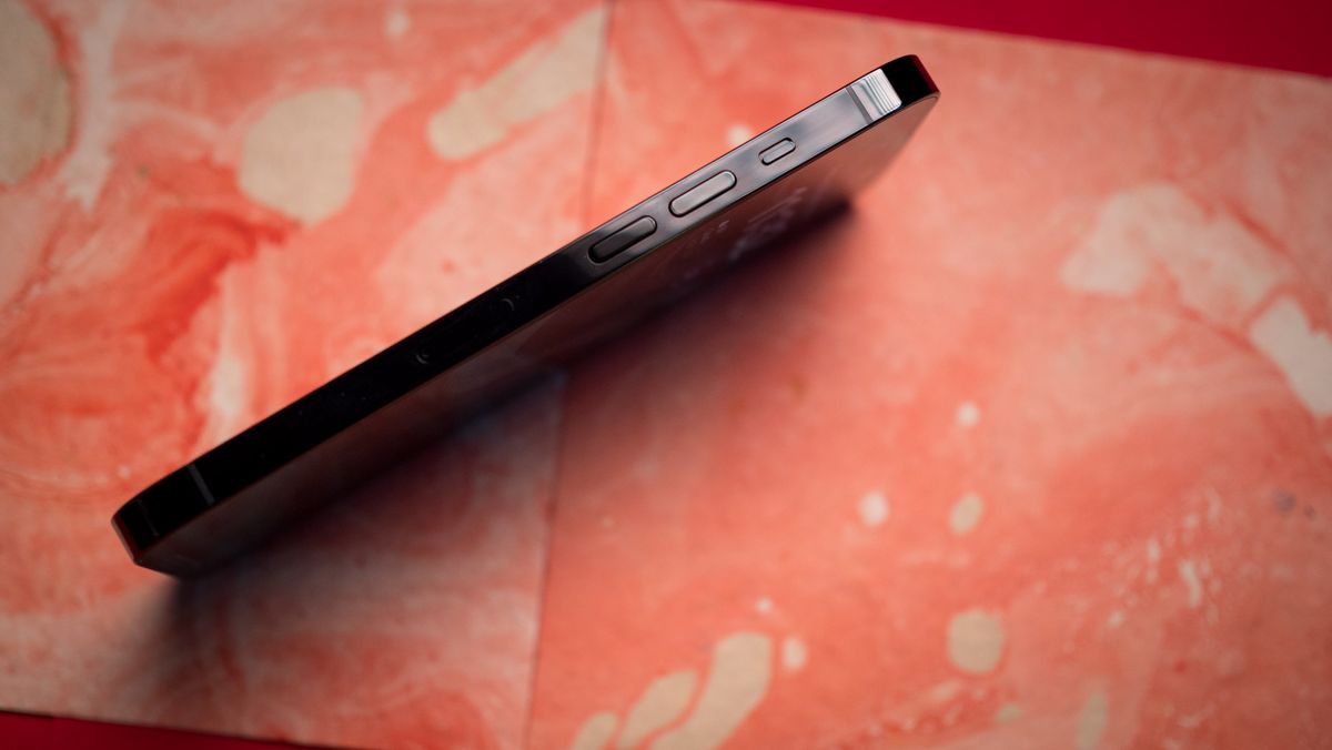 iPhone 14 Pro side view volume buttons on red background