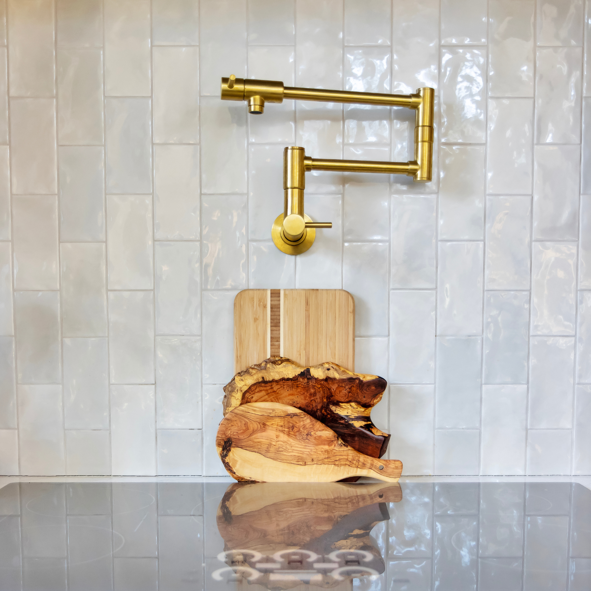 Gold pot filler on tiled backsplash.