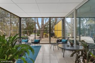 colourful views of michigan's modernist, single storey Frost House with large openings towards nature