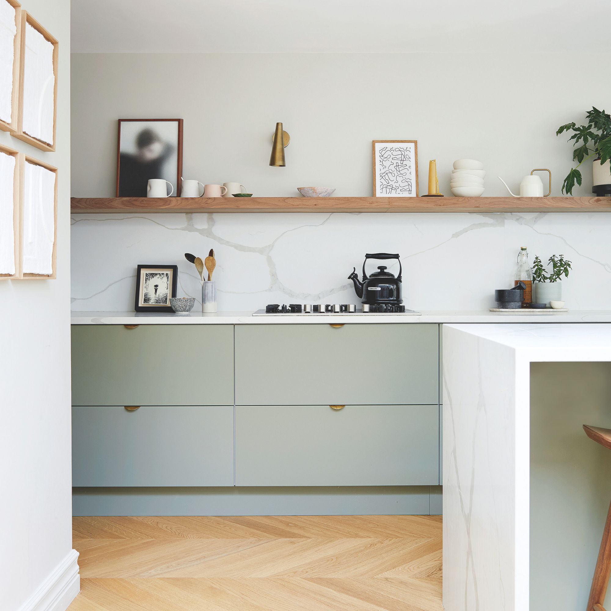 White painted kitchen with sage green cabinets and wooden floors