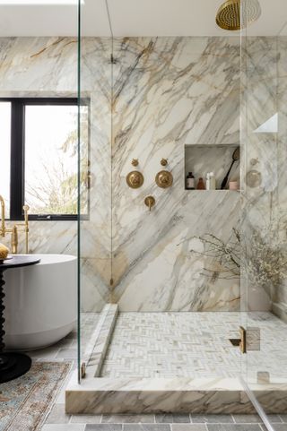Bathroom with marble slab walls and small-scale tile floor